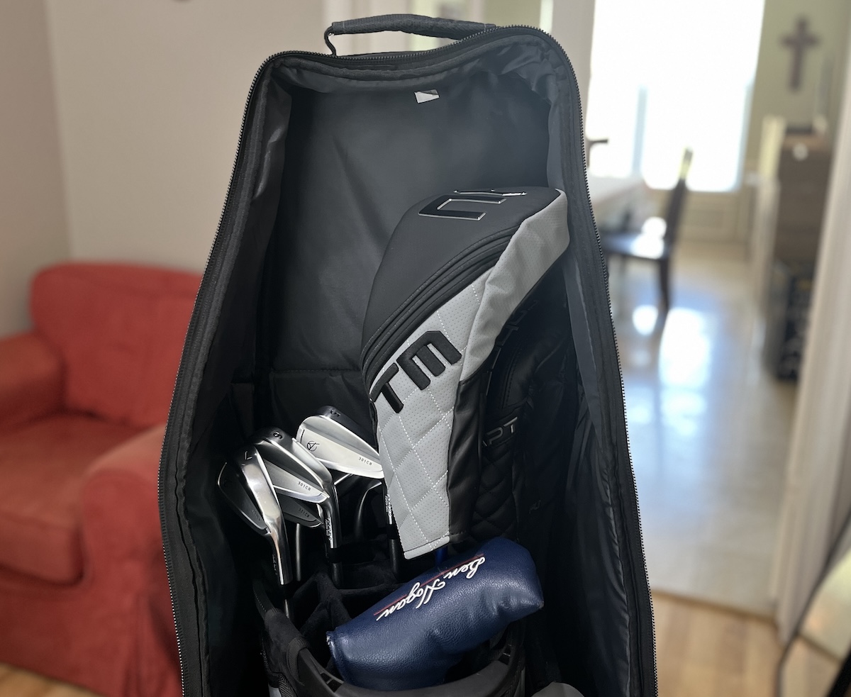 Bag Boy Freestyle travel cover open with a golf bag and clubs inside
